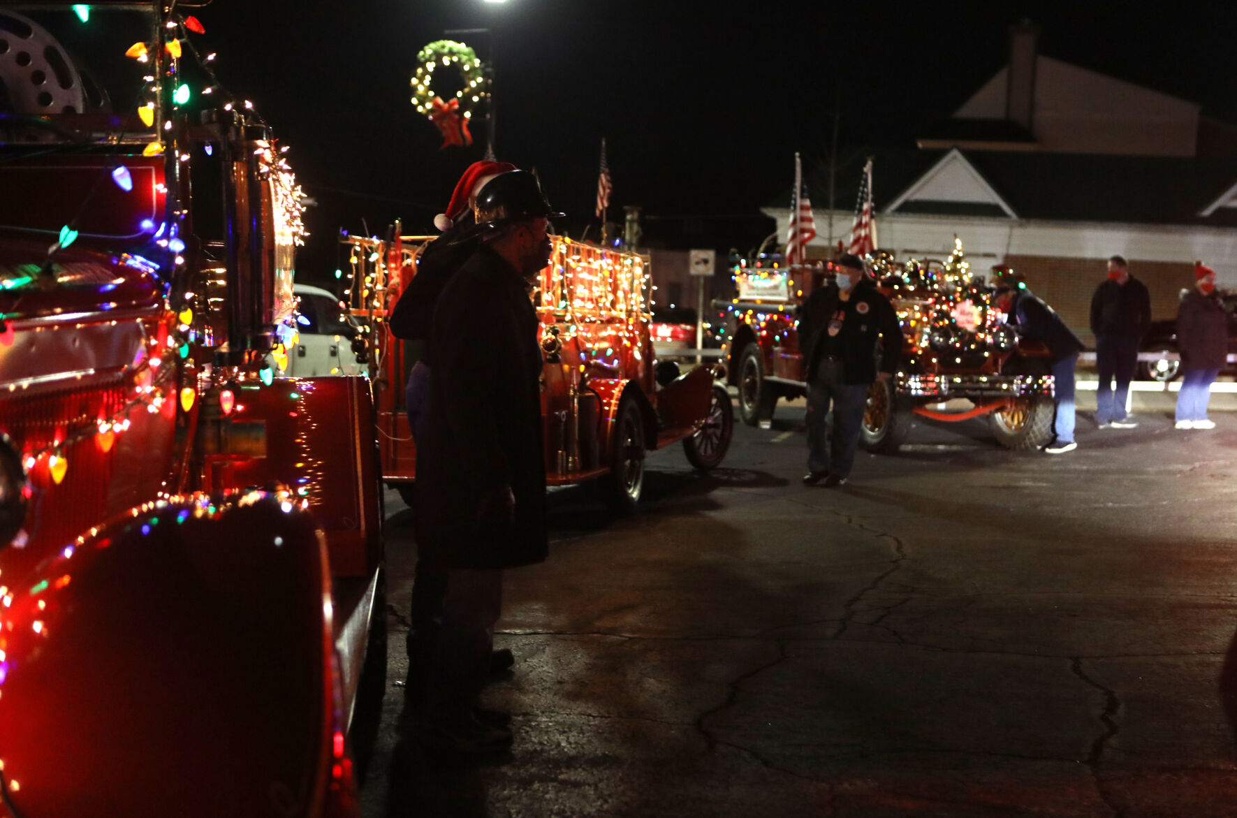 People stand near antique firetrucks